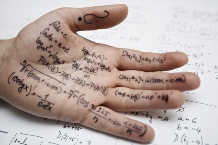 Close-up of a hand covered in formulas for a math class exam